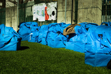 Nine blue soccer bags on the ground