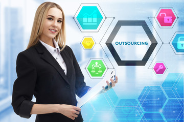 The concept of business, technology, the Internet and the network. A young entrepreneur working on a virtual screen of the future and sees the inscription: Outsourcing