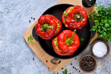 Red pepper stuffed with meat, bulgur and vegetables in a cast-iron pan. Baked stuffed peppers.