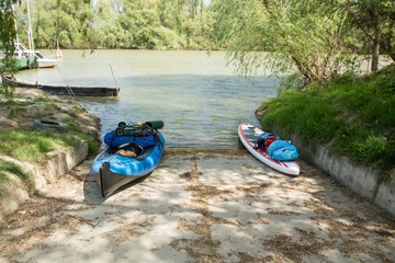 folding kayak and sup ready for expedition are standing near a berth