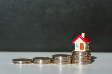 Miniature colorful house on pile of coins using as property and financial concept