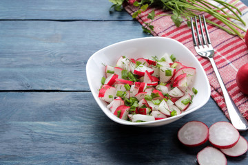 Salad of fresh radishes and fresh herbs on a blue wooden table. Spring vegetable salad. ingredients for cooking salad.