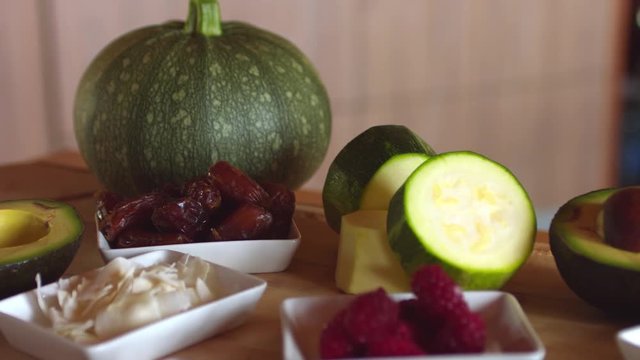 Ingredients to prepare a raw vegan dessert, presented on a wooden table