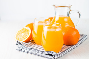 Close-up of a glass of orange juice with oranges fruits on wooden and stone background. Vitamins and minerals. Healthy drink and beverage concept.