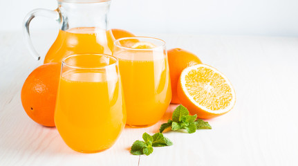 Close-up of a glass of orange juice with oranges fruits on wooden and stone background. Vitamins and minerals. Healthy drink and beverage concept.
