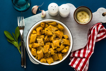 Italian gnocchi from pumpkin with parmesan cheese in a plate on a blue background. traditional dishes