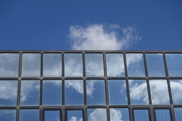 reflections clouds and blue sky on building windows