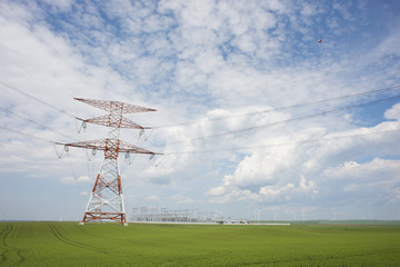 Fototapeta na wymiar Electricity or high voltage power lines with electricity station in rural landscape in a summer day