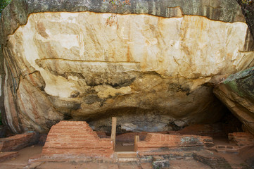 Ancient Buddhist monks meditation caves under big rocks in Sigiriya, Sri Lanka.