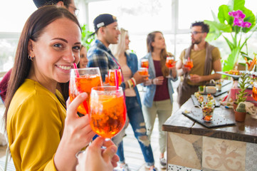 Group of friends toasting drink having fun on the bar restaurant