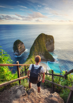 Traveler look at the ocean and rocks. Travel and active life concept. Adventure and travel on Bali, Indonesia. Travel - image