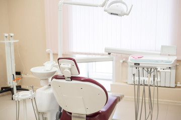 Empty dental chair in a bright medical office, rear view.