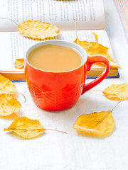 Cup of coffee, dry cracker cookies and dry leaves on an orange background. Autumn background, flat lay. Autumn composition. Autumn mood, top view. Cup of autumn coffee and yellow dry leaves.