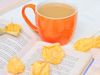 Cup of coffee, dry cracker cookies and dry leaves on an orange background. Autumn background, flat lay. Autumn composition. Autumn mood, top view. Cup of autumn coffee and yellow dry leaves.