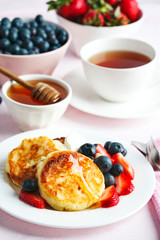 Cottage cheese pancakes with honey and berries for breakfast or lunch