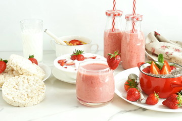 Strawberry smoothie or milkshake in a glass on marble background. Healthy food for breakfast and snack. copy space