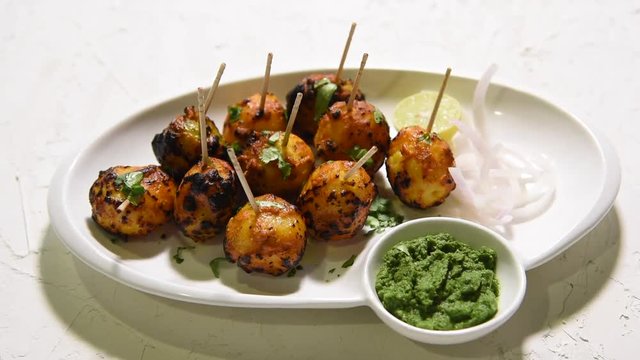 Tandoori aloo are roasted potatoes with Indian spices. It's a party appetiser served with green chutney. selective focus