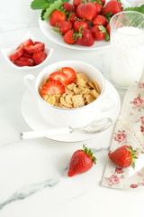 Healthy corn flakes with milk and strawberries for breakfast on marble background, desk, table.Top view. Copy space