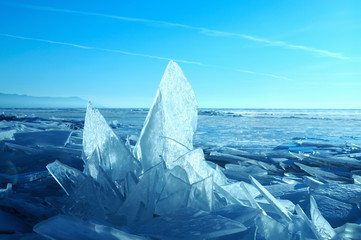 Sun rays are refracted by the transparent ice of Lake Baikal. crystal clear ice fragments —...