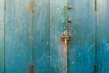 Green-Blue antique wooden door  closed with padlocks