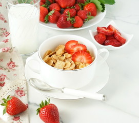 Healthy corn flakes with milk and strawberries for breakfast on marble background, desk, table.Top view. Copy space