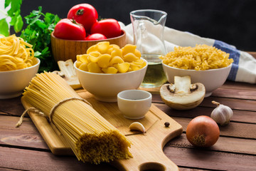 Fototapeta na wymiar italian food .ingredients for cooking raw pasta and fresh vegetables on wooden table soft focus