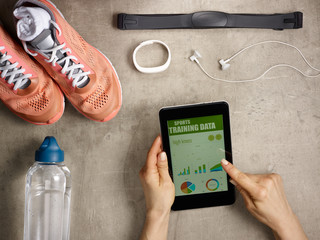 female hands holding tablet PC with sports training data