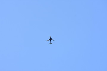 Tiny air plane in blue sky with copy space - travel, distance and minimalism concept