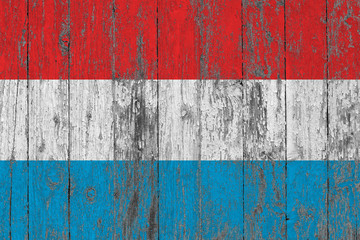 Flag of Luxembourg painted on worn out wooden texture background.