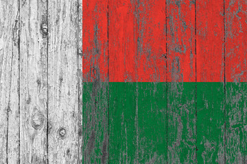 Flag of Madagascar painted on worn out wooden texture background.