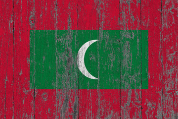 Flag of Maldives painted on worn out wooden texture background.