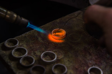 Fototapeta na wymiar Craft jewelery making with professional tools. Macro shot. A handmade jeweler process, manufacture of jewellery. Melting metal
