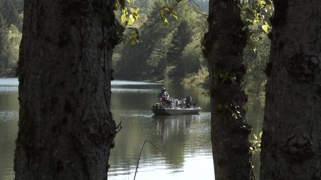 Fisherman Casting From Boat At The Lake