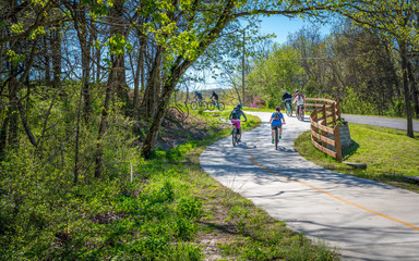 Family with kids biking on bike trail in Bella Vista, Northwest Arkansas - obrazy, fototapety, plakaty