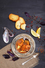 French seafood soup. Bouillabaisse ear of seafood. Vintage silver plated plate and spoon. Black...