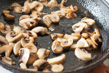 White champignons with mushrooms, fried in a pan, cooking ingredients for soup, salad. Vegetarian healthy protein food for the main course, lifestyle