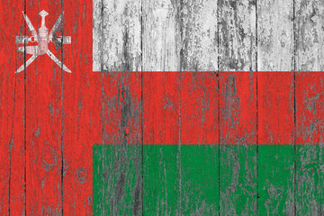 Flag of Oman painted on worn out wooden texture background.