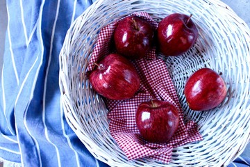 Jugosas manzanas rojas en cesta de mimbre
