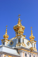 Fototapeta na wymiar Church golden cupola. Chapel with gilded domes close up view, christian temple isolated on blue sky 