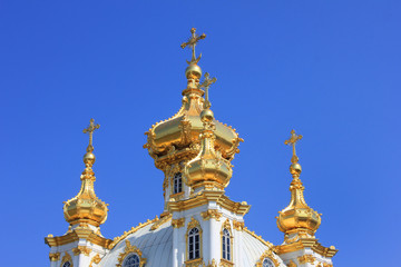 Fototapeta na wymiar Church cupola. Chapel with golden domes close up view on blue sky 