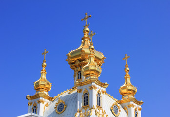 Fototapeta na wymiar Church golden domes with religious cross. Chapel cupola close up view on blue sky 