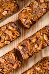 Chocolate brownie with nuts on a wooden board top view. Close up. Space