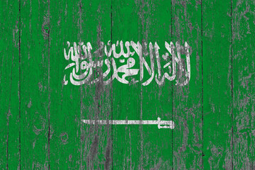 Flag of Saudi Arabia painted on worn out wooden texture background.