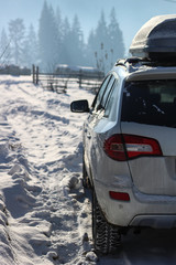 The car is white in the snow. Rubber on wheels in the snow. Snowy mountains of the Carpathians