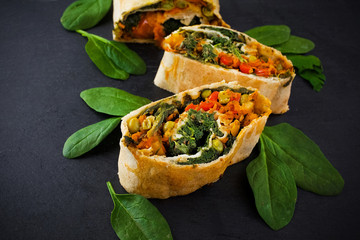 Vegetable savory strudel, with tomatoes, bell pepper, mushrooms on black background