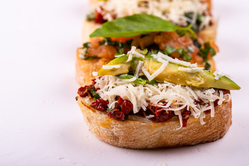 Set of assorted bruschetta with various toppings for holiday on white background. Macro. Party food concept.