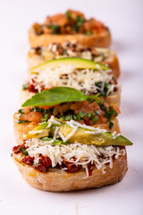Delicious Italian antipasti bruschetta on white background. Macro.