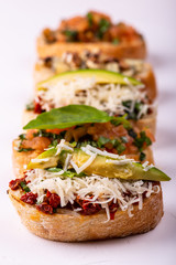 Set of assorted bruschetta with various toppings for holiday on white background. Macro. Party food concept.