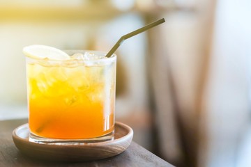 A glass of lemon ice tea on wood plate
