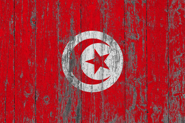 Flag of Tunisia painted on worn out wooden texture background.